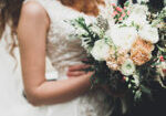 Beauty wedding bouquet with different flowers in hands.